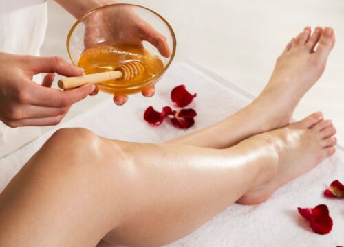 A luxurious body waxing session using a golden, honey-like wax for gentle hair removal.